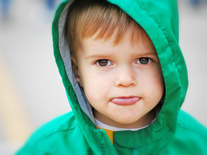 5 year old boy in hoodie showing tongue