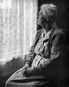 Elderly Lady pondering outside the window
