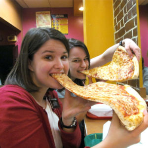 Two girls hogging in pizza