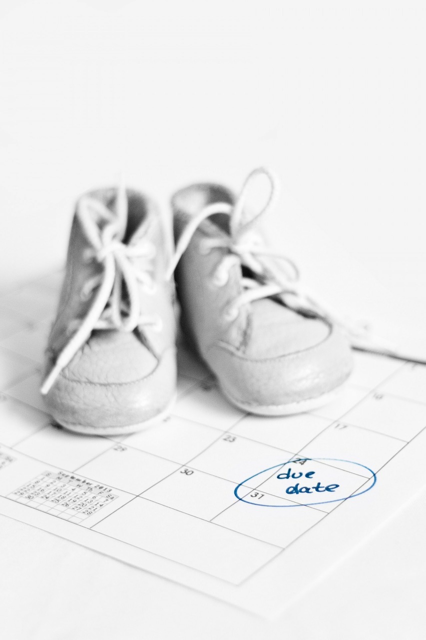 Baby's boots kept on top of a calendar maked due date
