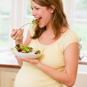 Pregnant woman eating food for two