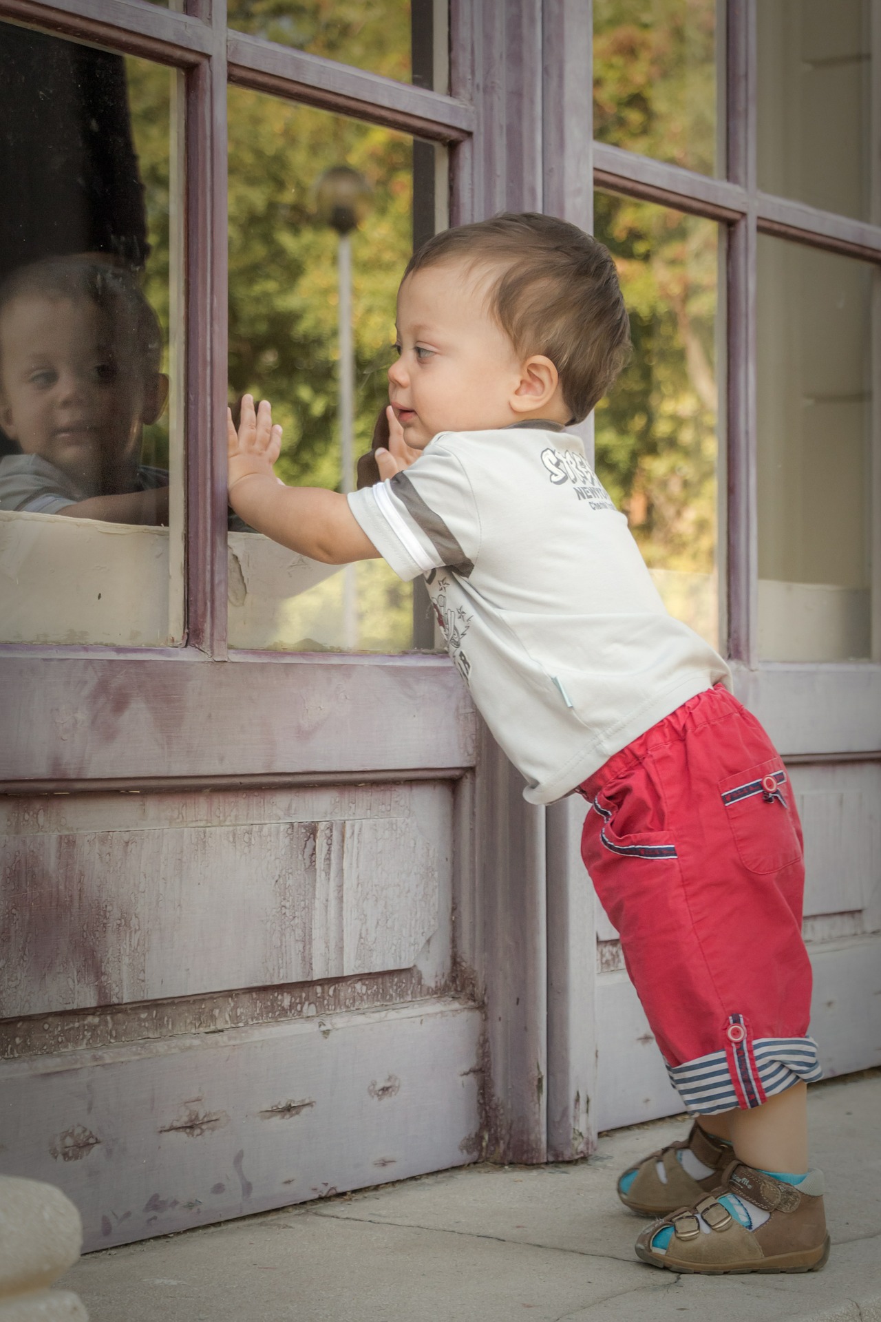baby standing near window